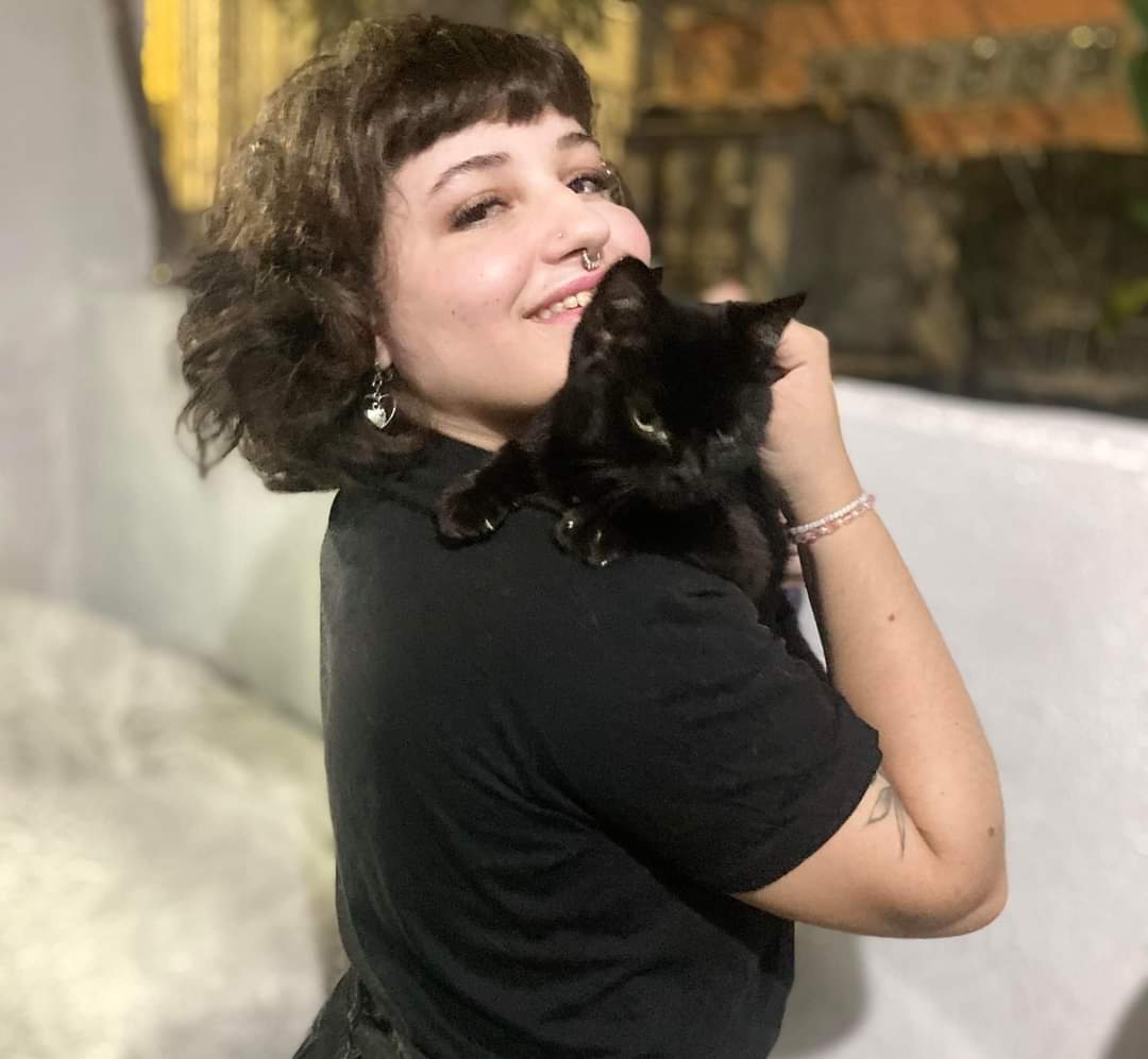 Dra. Jaqueline Neumann com um gato preto no ombro